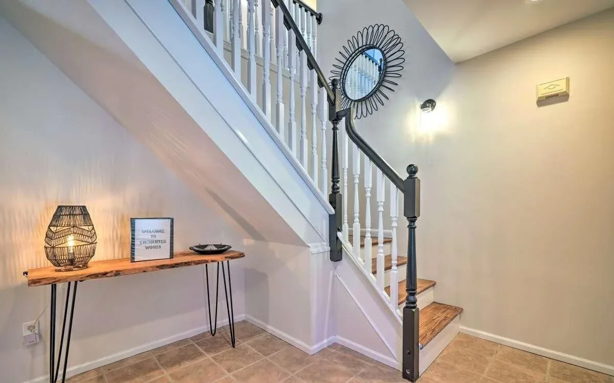 Poconos entry stairway with custom console, lighting, and black-and-white railing