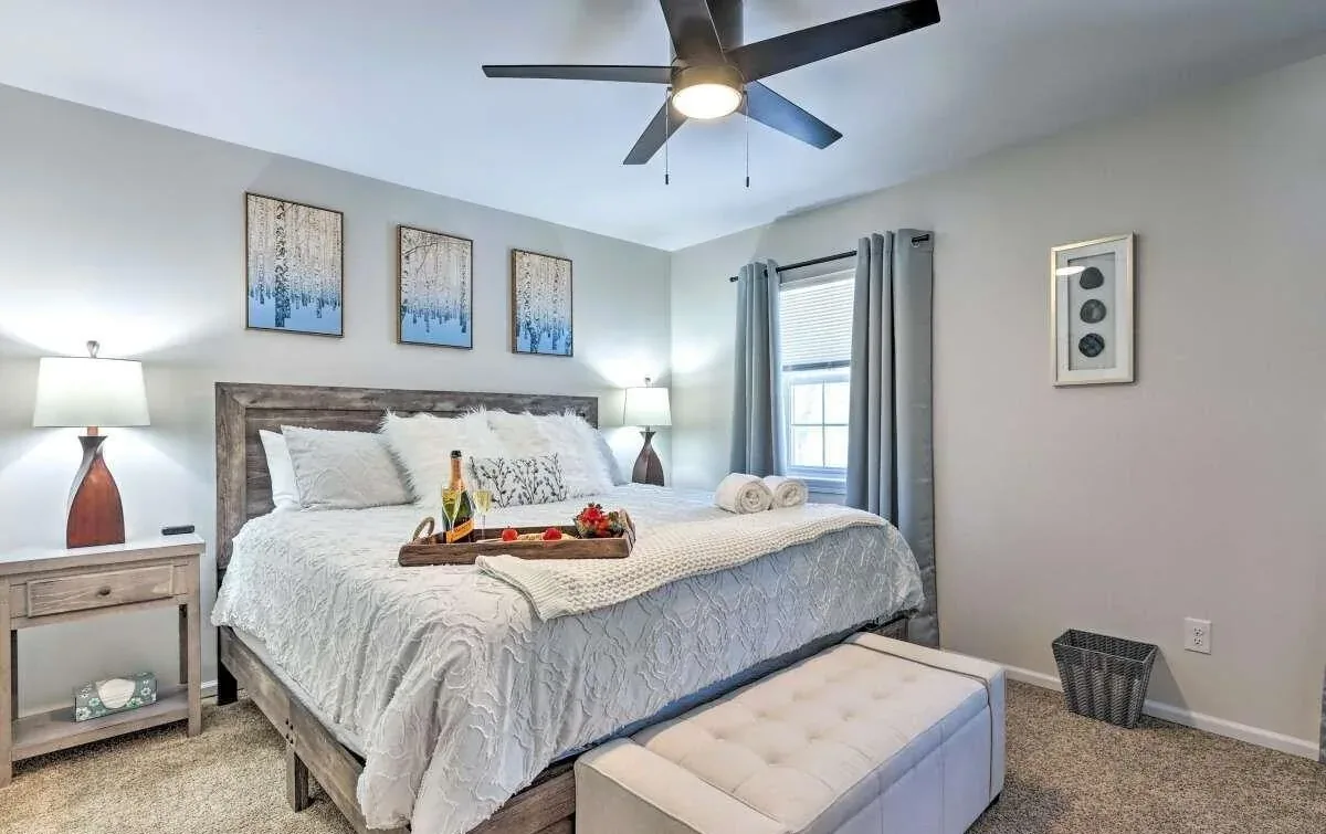 Poconos primary bedroom with king bed, layered neutral bedding, and coordinated artwork