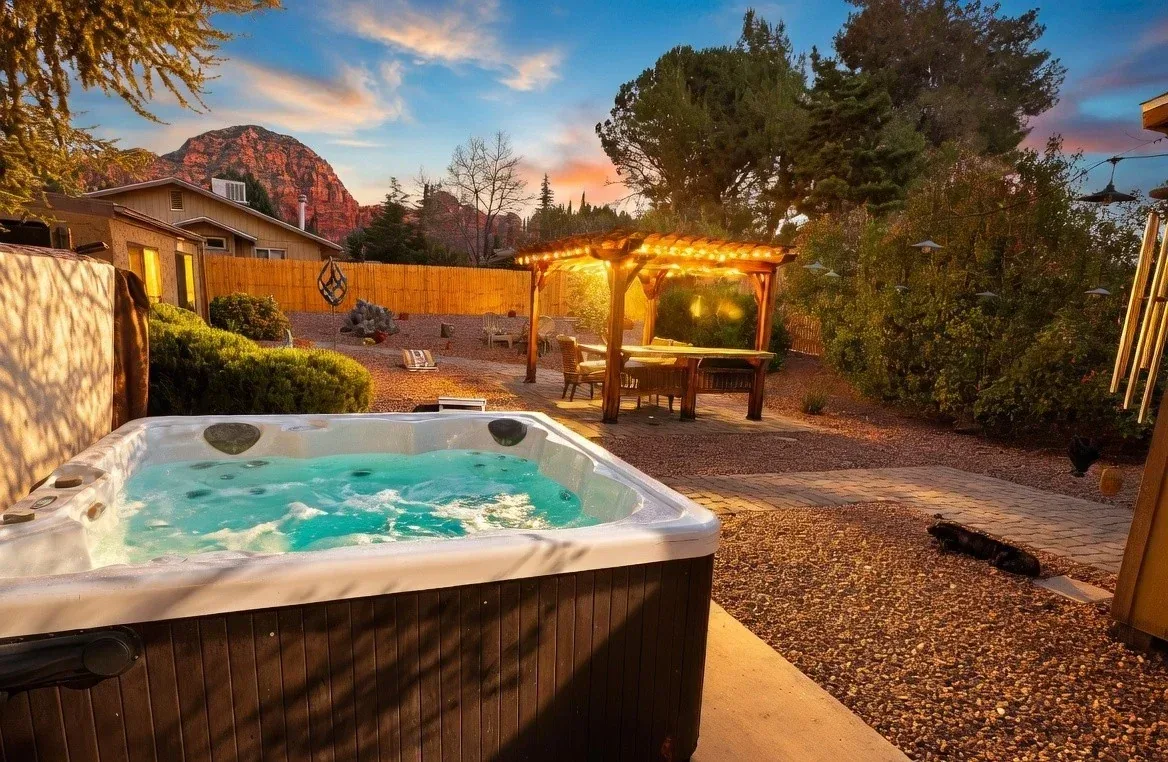 Sedona hot tub and illuminated pergola at sunset with red rock views