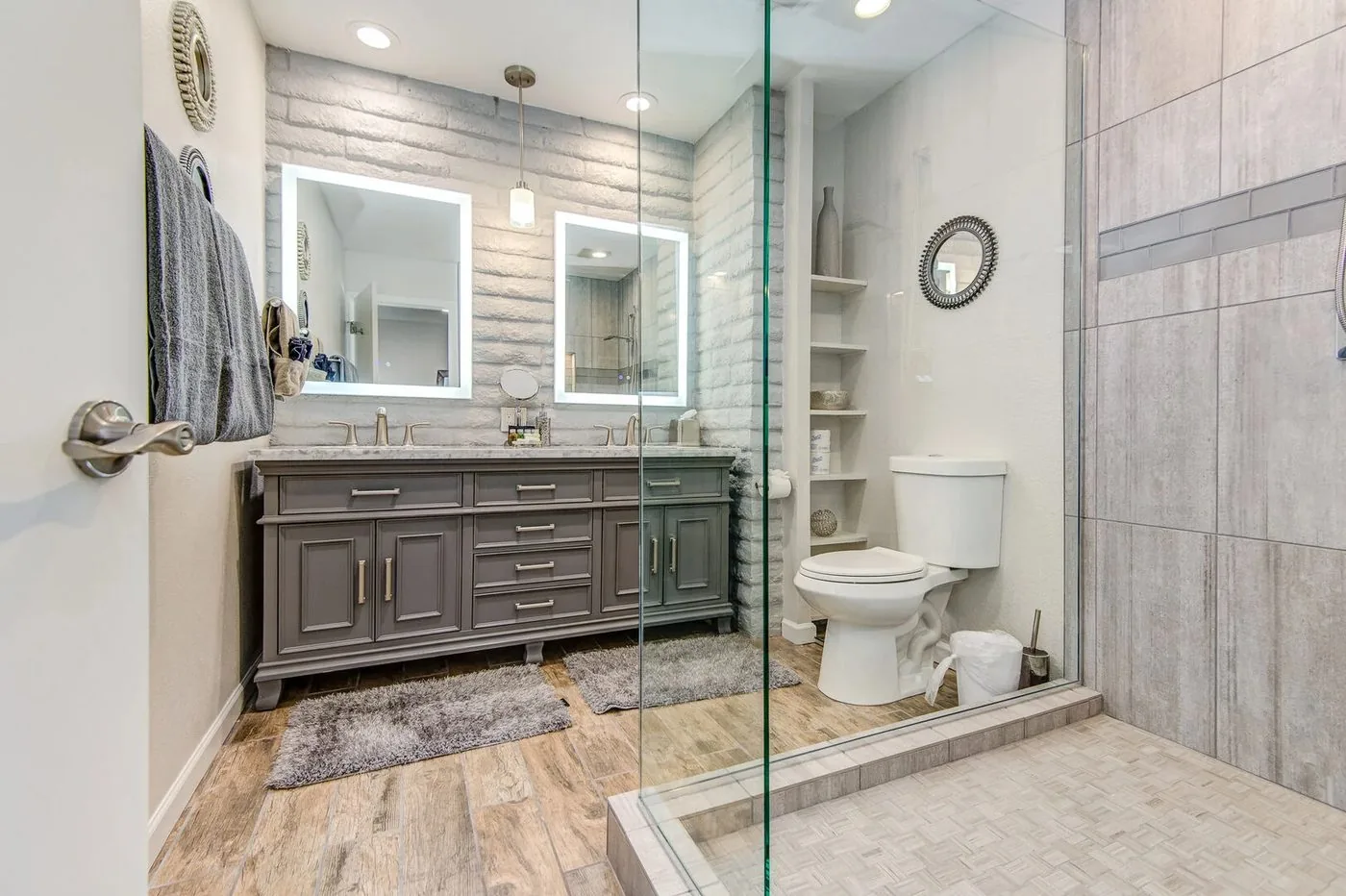 Sedona primary bath after: spa-style walk-in shower with gray tile, corner bench, built-in niche and glass enclosure