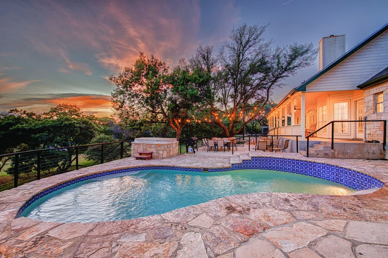 Texas Hill Country rental with a pool and outdoor entertaining area at sunset